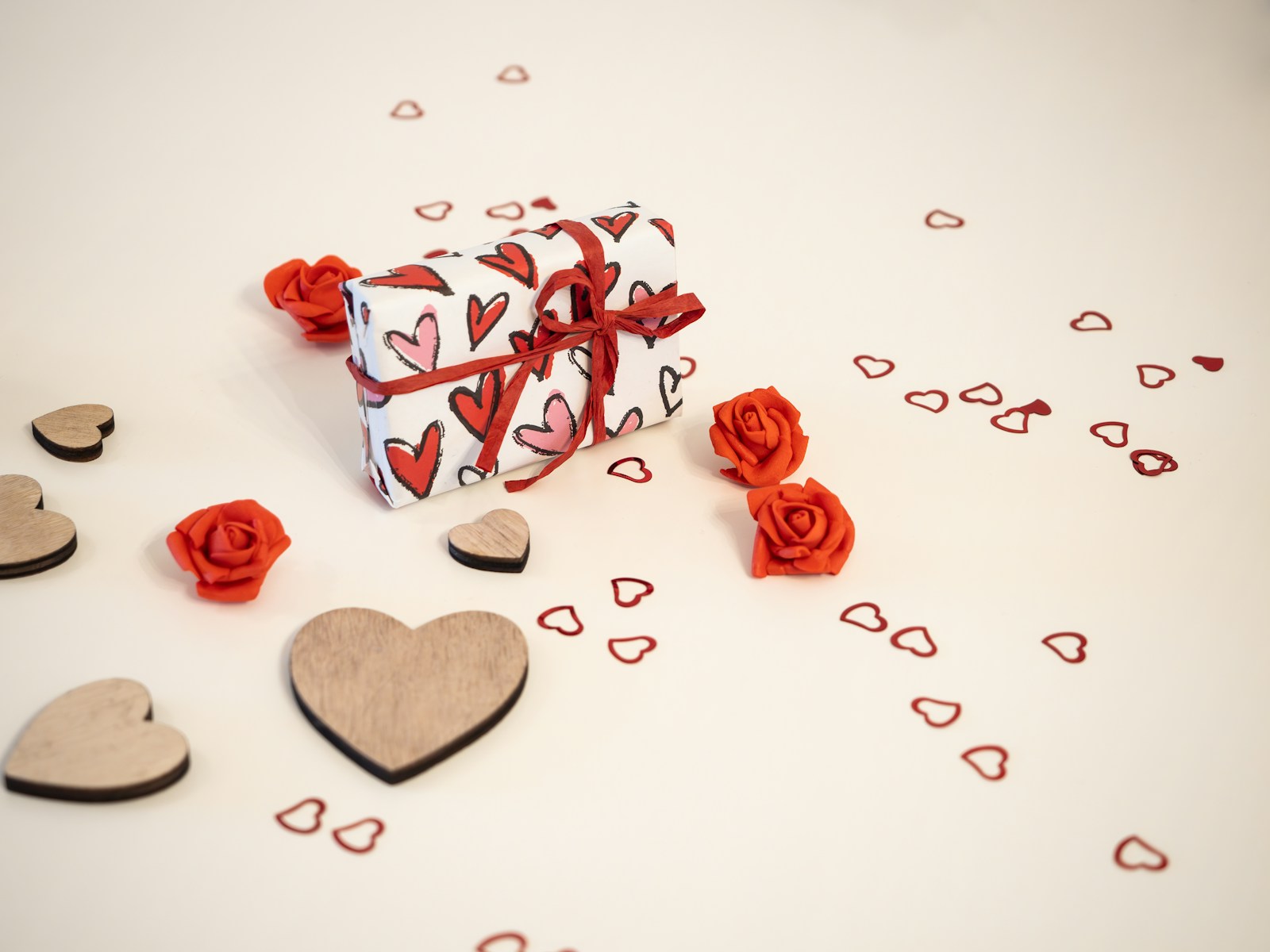 a gift box with hearts and roses on a table